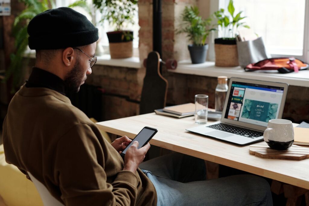  A man using his phone and laptop for online business and earning money online with affiliate marketing.
