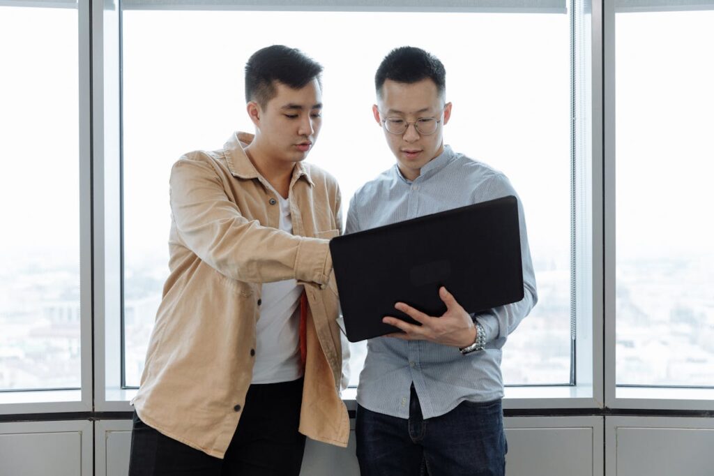  Two men attentively watching a live training on the shortcut to high-ticket sales.